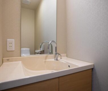 Compact bathroom washbasin with mirror and faucet at Ryokan Hitaya in Ōita, Kyūshū