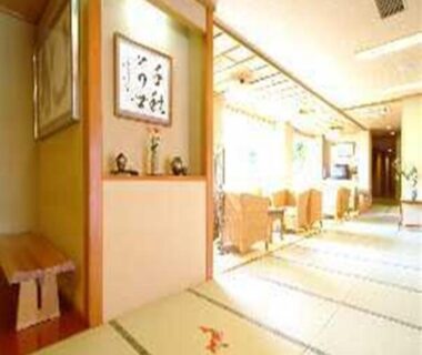 Sunlit tatami corridor with seating, shoji screens and calligraphy alcove at Ryokan Ichinomatsu, Hokkaido