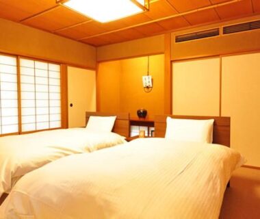 Twin beds on tatami floor with shoji screens and wooden ceiling at Ryokan Imai, Niigata