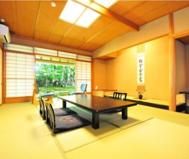 Traditional tatami room with low table, shoji screens and garden view at Ryokan Imai in Niigata