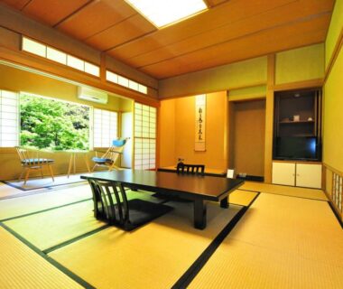 Traditional tatami room with low table, shoji screens and garden view at Ryokan Imai in Niigata
