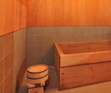 Compact wooden soaking tub with faucet, stool and tiled walls at Ryokan Imai, Niigata, Chūbu