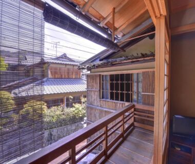 Wooden balcony with bamboo blind overlooking a traditional courtyard at Ryokan Inakatei in Kyoto, Kansai
