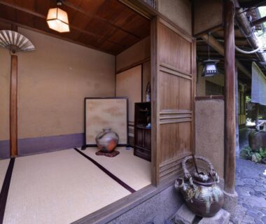 Tatami room with shoji screens, ceramic vase and wooden entrance at Ryokan Inakatei Kyoto Kansai