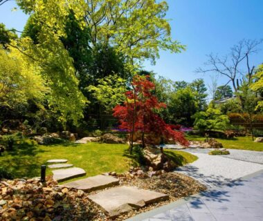 Sunlit stepping stone garden with red maple at Ryokan KANADE in Kyoto