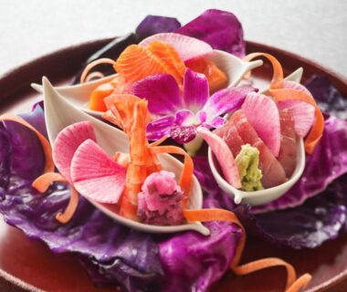 Edible flowers and vegetable garnish on dark wooden plate at Ryokan KANADE Kyoto Kansai Japan