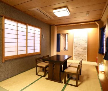 Tatami room with low dining table, low chairs, shoji screens and alcove at Ryokan Kamogawa Asakusa Tokyo