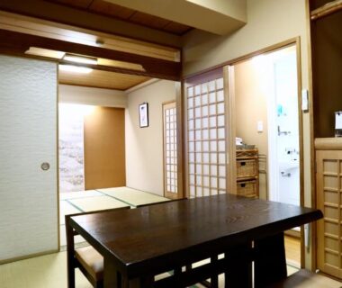Tatami room with low table, shoji screens and TV at Ryokan Kamogawa Asakusa in Tokyo