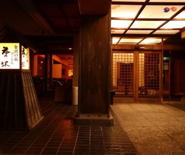 Lantern-lit wooden entrance with tiled floor and lattice doors, Ryokan Karasawa, Chubu Ishikawa, Japan