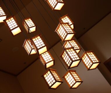 Warm wooden shoji lanterns hanging from an interior ceiling at Ryokan Karasawa, Ishikawa, Chūbu