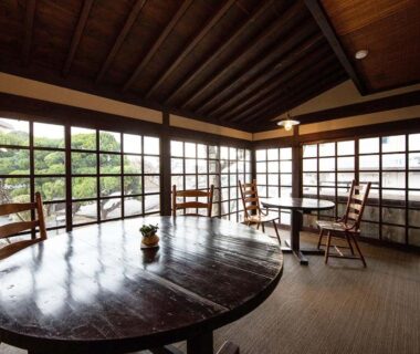 Round wooden table and chairs, shoji screens overlooking garden, Ryokan Kiraku Ōita Kyūshū Japan