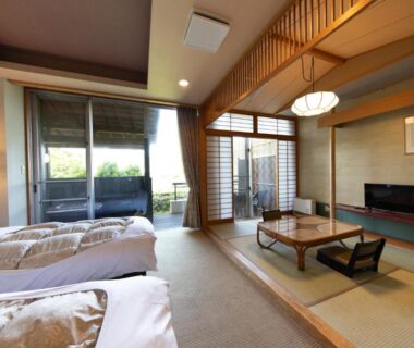 Tatami living area with low table, twin beds, shoji screens and balcony opening to garden view