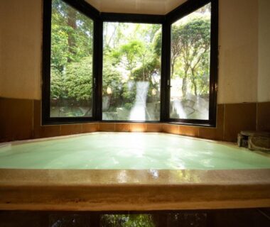 Indoor onsen bath with garden waterfall view at Ryokan Kiritani Hakoneso, Kanagawa, Japan