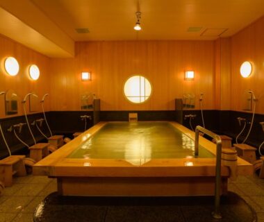 Indoor wooden onsen bath with shower stations at Ryokan Kohro in Kyoto, Kansai