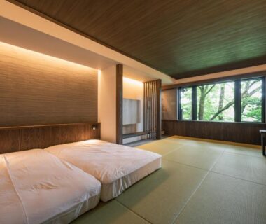 Spacious tatami room with two futons and garden-facing window at Ryokan Kono-Yu in Kumamoto