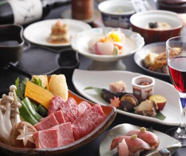 Marbled beef and vegetable platter with assorted side dishes and wine glass at Ryokan Kutsuroginoya Yuu, Gifu