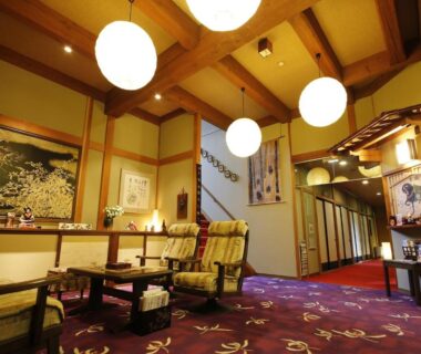 Lobby with wooden beams and round lanterns at Ryokan Kutsuroginoya Yuu Gifu