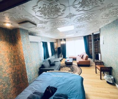Room with blue bedspread, sofa seating, ornate ceiling and wood floor at Ryokan La Luna in Shizuoka