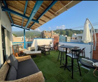 Rooftop terrace with sofa, wicker chairs, high tables and umbrella at Ryokan La Luna in Shizuoka hills