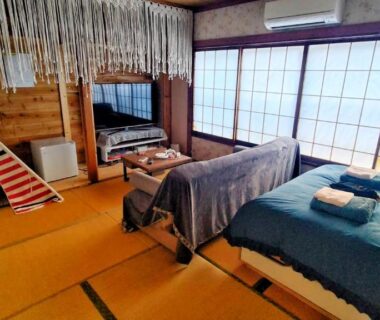 Tatami room with shoji screens, two low beds and a small teepee at Ryokan La Luna, Shizuoka