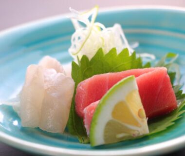 Tuna and white-fish sashimi on blue ceramic plate with shiso and lime served at Ryokan Maruya in Oita
