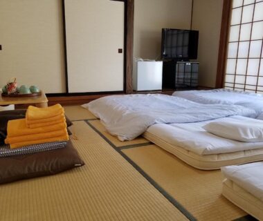 Futons on tatami with shoji screens and folded towels at Ryokan Matsukaze, Nagano, Chūbu, Japan