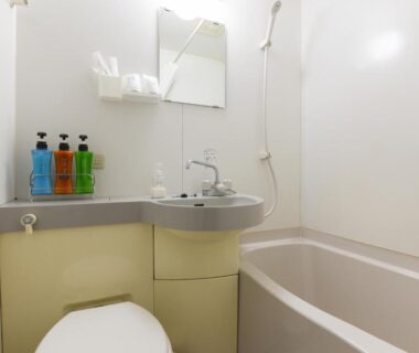 Small bathroom with bathtub, shower, sink and toiletries at Ryokan Mikawaya in Tokyo, Kantō, Japan