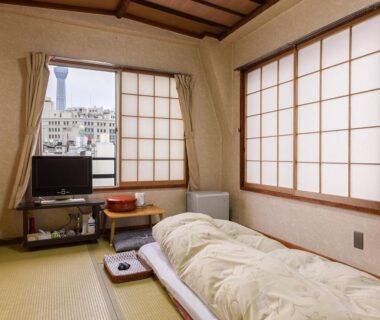 Tatami room with futon, shoji screens and low table at Ryokan Mikawaya in Tokyo