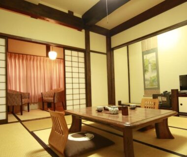 Traditional tatami room with low table, floor chairs, shoji screens, tokonoma alcove and seating area at Ryokan Murayama Gifu