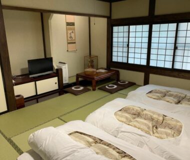 Tatami room with futons, shoji screens and low table at Ryokan Murayama, Chūbu Gifu Japan
