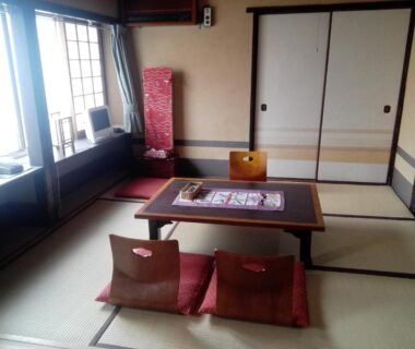 Japanese tatami room with low table, floor cushions, shoji window and sliding fusuma doors at Ryokan Nakajimaya in Kyoto