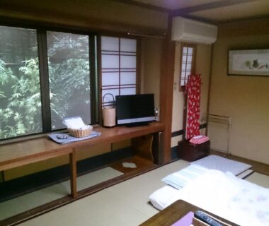 Tatami room with futons, shoji screens and garden view at Ryokan Nakajimaya, Kyoto