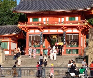 Vermilion shrine gate with stone steps and visitors outside Ryokan Nakajimaya Kyoto