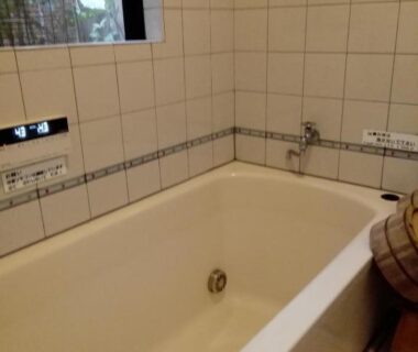 Tiled bathtub with faucet and window in Ryokan Nakajimaya bathroom, Kyoto Kansai