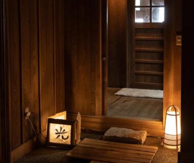 Low-lit wooden entrance with lanterns and step-up foyer at Ryokan Nanjoen in Kumamoto