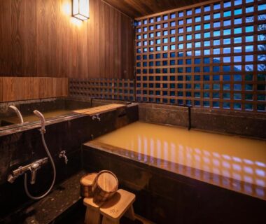 Indoor wooden onsen tub with lattice screen at Ryokan Nanjoen in Kumamoto, Kyūshū, Japan