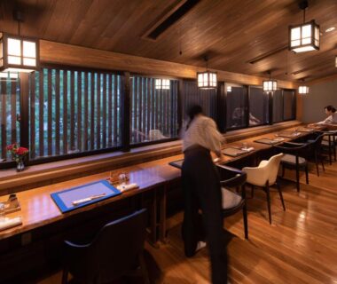 Staff arranging place settings along wooden counter dining at Ryokan Nanjoen, Kumamoto, Kyūshū