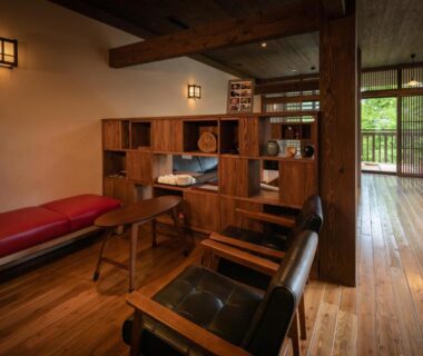 Lounge with wooden floors, seating and slatted screens at Ryokan Nanjoen, Kumamoto, Kyūshū