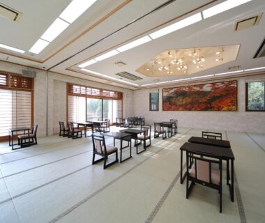 Spacious tatami dining area with low tables and mural at Ryokan Nenrinbo in Kyoto