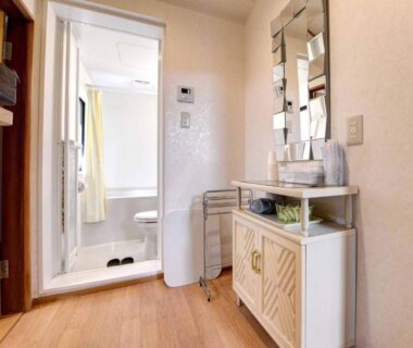 Entry corridor with washstand, mirror and wooden floor at Ryokan Niko in Tokyo, Kantō