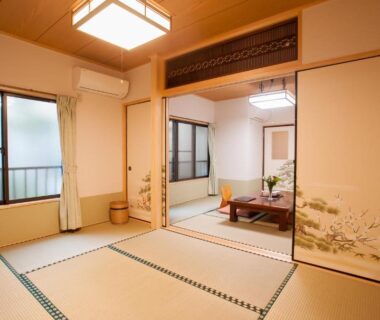 Tatami room with low dining table, fusuma sliding doors and windows at Ryokan Niko, Tokyo, Kantō, Japan
