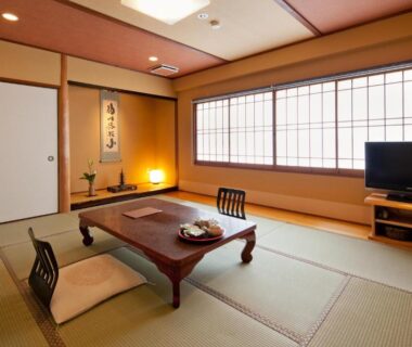 Tatami room with low table, zabuton cushions, shoji window and tokonoma at Ryokan Oomuraya, Saga, Kyūshū, Japan