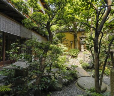 Serene inner garden with stone lantern, stepping stones and wooden veranda at Ryokan Sanga in Kyoto, Kansai