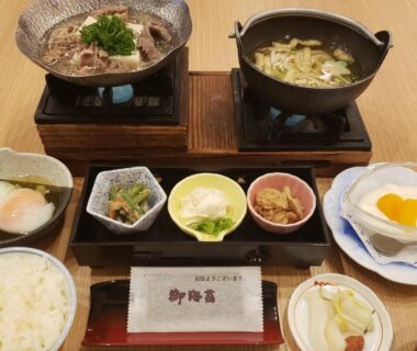 Tabletop Japanese meal with rice, small side dishes and two simmering pots at Ryokan Sanoya Kyoto