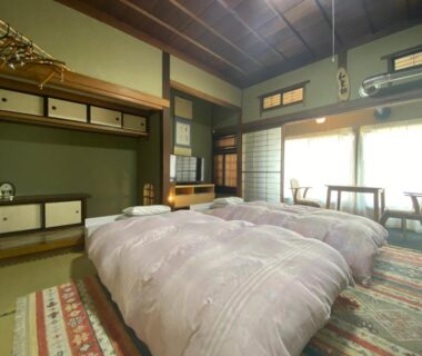 Tatami room with two futons, shoji screens and wooden ceiling at Ryokan Sansui in Hokkaidō