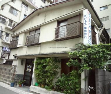 Two-story street-facing ryokan with entrance greenery at Ryokan Sansuiso in Tokyo Kanto