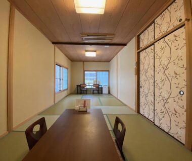 Traditional tatami room with low table, zaisu chairs and sliding fusuma doors at Ryokan Sawaya Honten in Kyoto