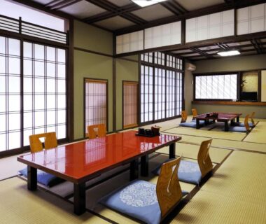 Traditional tatami room with low lacquered dining table and shoji screens at Ryokan Seishounagon in Mie