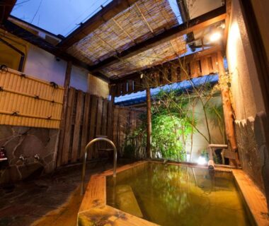 Wooden onsen bath with bamboo fencing at Ryokan Sennari in Oita, Kyūshū, Japan