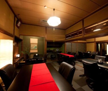 Traditional dining area with long tables and warm lighting at Ryokan Sennari, Ōita